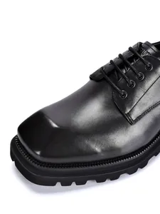 Detailansicht der hochwertigen schwarzen Lederstruktur von Derby-Schuhen mit Karree-Zehe