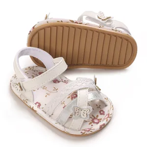 Detailopname van babysandalen met bloemenpatroon en flexibele bruine rubberen zool.