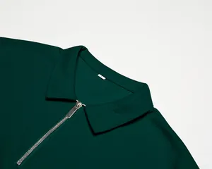 Gros plan d'un polo pour homme en maille gaufrée vert foncé avec détail de col à fermeture éclair