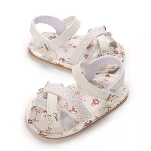Detail van witte baby sandalen met mooie bloemenprint, vlinders en zachte zolen