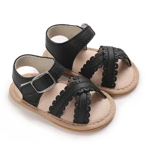 Detailopname van zwarte baby sandalen met geschulpte bandjes en verstelbare gesp