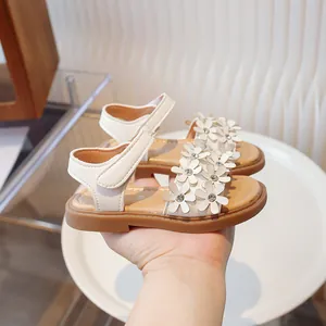 Elegant white girls' floral sandals with soft brown soles and sparkling rhinestone details