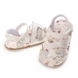 Detailopname van witte baby sandalen met bloemenprint, zachte zool en kanten details
