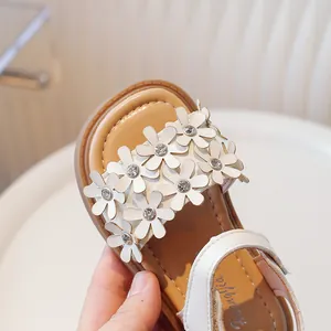 Detailed view of white girls' floral princess sandals with soft soles and rhinestones.
