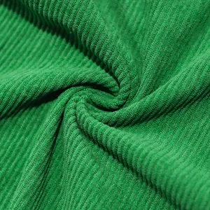 Close-up macro view of vibrant green heavy-weight corduroy fabric texture.