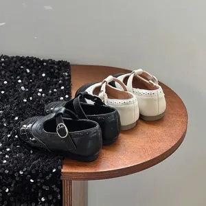 Vista dettagliata delle scarpe Mary Jane nere e beige per bambine con motivi brogue