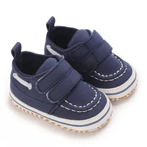 Gros plan de chaussures de marche pour bébé en toile bleu marine avec double bande auto-agrippante