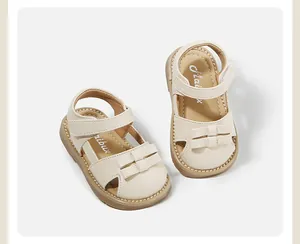 Detailed view of cream toddler girls' sandals with bow accents and velcro straps