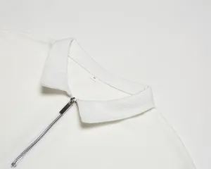 Détail macro du polo en maille gaufrée blanche avec fermeture éclair et texture