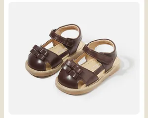 Classic brown toddler girl sandals featuring a decorative bow and secure velcro strap