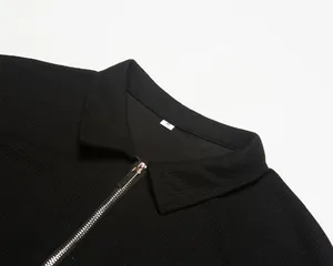 Gros plan d'un polo pour homme en maille gaufrée noire avec détails de fermeture éclair