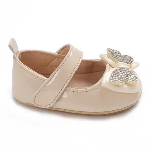 Detalle de zapato de fiesta para bebé niña crema con lazo de mariposa de diamantes