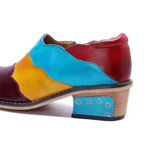 Dettaglio scarpe in pelle patchwork colorate fatte a mano con motivo floreale sul tacco