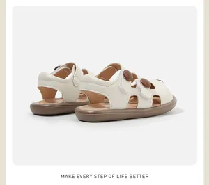 Vista trasera de sandalias beige cerradas para bebé con suelas marrones y velcro.