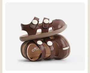 Primer plano de sandalias de verano marrones para niños con botones decorativos