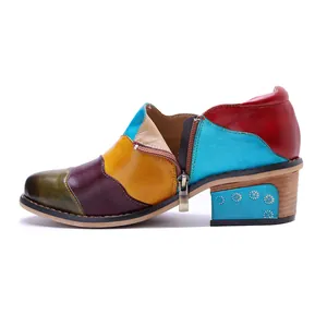 Vista laterale di scarpe in pelle patchwork fatte a mano con tacco largo e cerniera