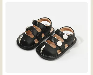 Vista detallada de sandalias negras cerradas para niños con detalles circulares blancos