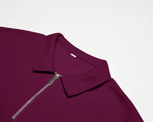 Gros plan d'un polo bordeaux en maille gaufrée avec fermeture éclair