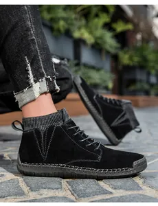 Nahaufnahme von schwarzen Wildleder-Stiefeletten mit Kontrastnähten und Gummisohle