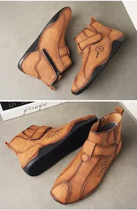 Detalle de botas altas marrones para hombre con cremallera y correa