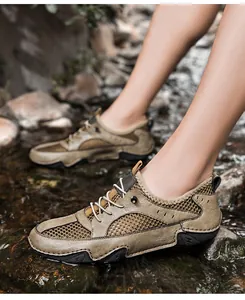 Detail van ademende leren outdoorschoenen voor heren op stenen in een beekje