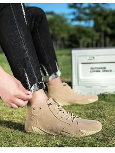 Detailweergave van heren khaki hoge Martin boots met suède textuur in het groene gras