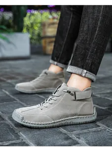 Detail view of grey high-top Martin boots featuring handmade stitching and side buckle