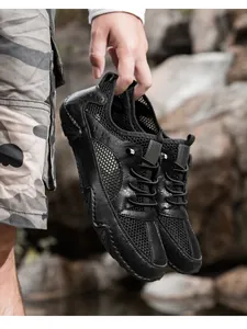Detail van ademende leren mesh sportschoenen voor heren tegen een rotsachtige achtergrond