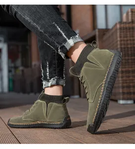Detailansicht grüner Wildleder-Stiefel mit handgenähten Details und Strickbündchen.