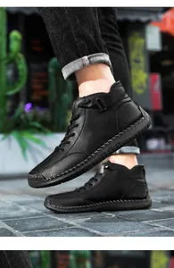 Close-up of black hand-stitched high-top men's casual boots in an urban setting
