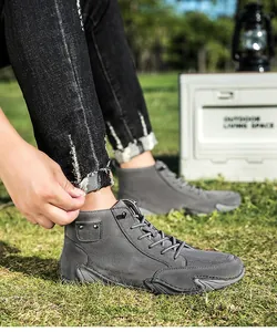 Gedetailleerde opname van grijze heren veterlaarzen op gras met een antislip zool