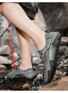 Duurzame grijze leren wandelschoenen voor heren in een natuurlijke rotsachtige beek