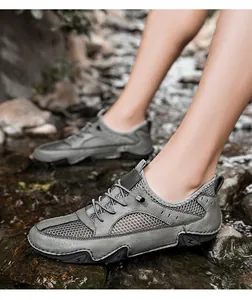 Gedetailleerd overzicht van ademende heren wandelschoenen van rundleer bij een beekje buiten