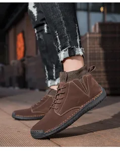 Detailansicht von braunen Wildleder-Stiefeletten für Herren mit Gummisohle und Ziernähten.
