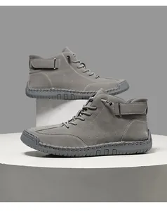 Side view of grey handmade stitched men's high-top Martin boots on white platforms