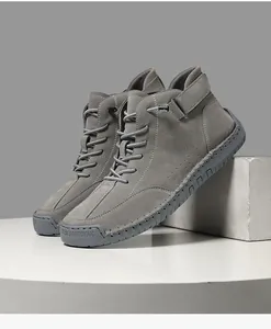 Detailed view of hand-stitched grey suede high-top Martin boots with durable rubber soles
