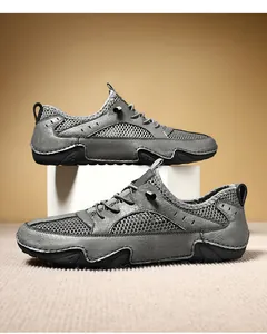 Zijaanzicht van grijze herensneakers met ademend mesh en lederen inzetstukken