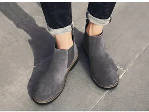 Modische graue Chelsea-Boots aus Wildleder für Herren auf Steinpflaster für den Winter.