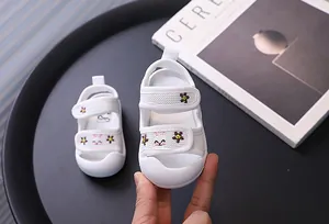 Detailansicht von atmungsaktiven weißen Baby-Netzsandalen mit süßen Tierstickereien.