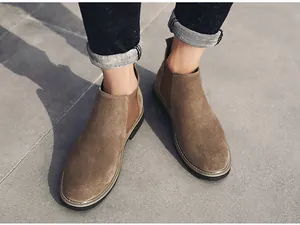 Nahaufnahme von braunen Chelsea-Boots aus Wildleder für Herren auf dem Gehweg