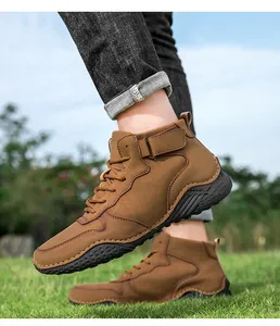 Vue latérale détaillée des bottines d'extérieur marron pour hommes sur l'herbe