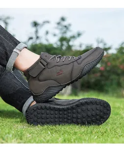 Vue détaillée de bottines d'extérieur brunes avec semelle antidérapante sur l'herbe