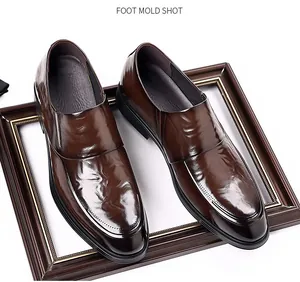 High-gloss polished brown leather men's dress loafers featuring intricate stitching details