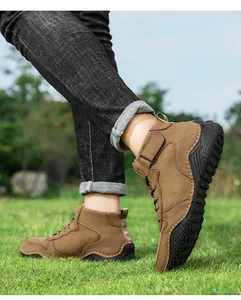 Vue détaillée de bottines de randonnée marron pour hommes sur de l'herbe fraîche