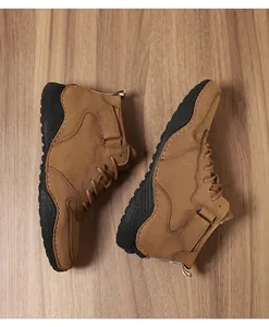 Vue détaillée de dessus de bottines de plein air brunes pour hommes sur un fond de bois