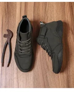 Vue de dessus de bottines d'extérieur olive foncé sur un fond en bois rustique