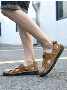 Vue détaillée de profil des sandales de plage en cuir marron pour hommes en extérieur.