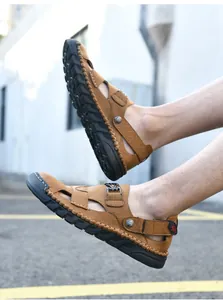 Gros plan de sandales de plage marron cousues main pour hommes avec semelles noires