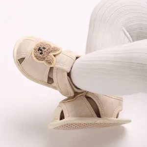 Vue détaillée de chaussures de marche bébé beiges avec ours de dessin animé et semelle