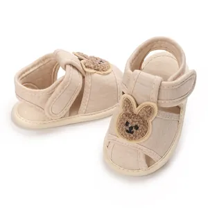 Détail de jolies chaussures de marche beige pour bébé avec semelle souple et lapin.